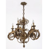 <p>Elegante lustre de bronze, com 5 luzes. Estrutura ricamente ornamentada, com figuras de anjos alados, volutas, elementos vegetais - 100 cm alt</p>
