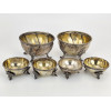 <p>Lote com seis petisqueiras em prata 833 Adriano, sendo duas maiores e quatro menores, todas apoiadas sobre p&eacute;s vazados de desenho em relevo. Bordas molduradas e acabamento liso no interior - Di&acirc;metros: 11 cm (maiores) e 7 cm (menores) - peso 666 g</p>