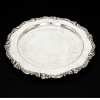 <p>Bandeja circular de prata 925 Camusso (Peru), borda recortada e ricamente decorada com volutas em relevo. Marca Indústria Peruana – Plata Esterlina 925 – Camusso. Medindo 35 cm de diâmetro. Peso 888 g</p>