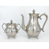 <p>Lote com 2 peças, composto por bule para café (23 cm alt) e açucareiro (14 cm alt), de metal prateado, manufatura alemã Eduard Hueck, decoração floral gravada, pés recortados e pegas decoradas</p>