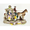 <p>Grupo escultórico em porcelana alemã, representando carruagem de estilo rococó puxada por dois cavalos, com cocheiro e casal trajando vestimentas de época. Rica decoração policromada, com marca na base - 25 x 20 cm alt</p>