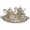 <p>Lote de serviço para chá e café de metal prateado, composto por bandeja oval e quatro peças: cafeteira, chaleira, açucareiro com tampa e leiteira. Peças com decoração em frisos em relevo e pegadores de linhas clássicas. Bandeja medindo 55 cm de comprimento. (Apresenta quebra na dobradiça da tampa da chaleira)</p>