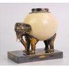 <p>Escultura de metal e ovo de avestruz representando elefante, parte superior com tampa. Alt. 21 x 20 x 12cm. (precisa restauro na pega superior / presas com restauro)</p>