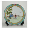 <p>Prato de porcelana oriental esmaltada, ornamentado com figuras em cena de jardim, marca vermelha sob a base. Diam. 24 cm. China, séc. XX (com pequeno restauro na borda)</p>