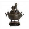 <p>Incensário de bronze patinado, estilo arcaico, ornamentado com figuras de cães de fó, sobre base de madeira. alt. 23 x 18 x 14cm (total c/ base). China, início séc. XX (pega superior precisa solda)</p>