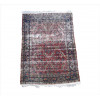<p>Tapete persa Kirman, decoração floral em composição all-over com arabescos, palmetas e delicadas ramagens entrelaçadas sobre campo vermelho rubi, borda principal azul-marinho decorada com florões e motivos vegetais estilizados em rica policromia, 205 x 140 cm = 2,87 m² (no estado / rape / com pequenos rasgos nas laterais)</p>