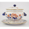 <p>Sopeira de porcelana esmaltada à mão, ornamentada com motivos florais, à maneira China- Imari, decorada com motivos florais, pegas laterais em forma de cabeças de animais, acompanha respectivo presentoir. Alt. 24 x 29cm. (total). Séc. XX</p>