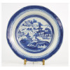 <p>Prato de porcelana Macau, esmaltado nas tonalidades azul e branco, decorado com paisagem lacustre e pagodes. Diam. 23cm. China, séc. XVIII (com fio de cabelo)</p>