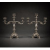<p>Par de candelabros de prata-de-lei, contraste Águia, ricamente decorados com guirlandas, rocalhas e ramagens, sobre fundo guillhoce na base e canelado na parte superior, suporte para tries velas. Alt. 33 x 30 x 11cm. Portugal, início séc. XX</p> <p>Par de candelabros de prata-de-lei, contraste Águia, ricamente decorados com guirlandas, rocalhas e ramagens, sobre fundo guillhoce na base e canelado na parte superior, suporte para tries velas. Alt. 33 x 30 x 11cm. Portugal, início séc. XX</p>