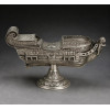 <p>Naveta de prata-de-lei sem contraste, representando forma de navio europeu, ricamente decorada com cinzelados, guirlandas e ramagens, parte frontal com carranca de leão estilizado. Alt. 16 x 28 x 09cm. Brasil Séc. XVIII</p> <p>Naveta de prata-de-lei sem contraste, representando forma de navio europeu, ricamente decorada com cinzelados, guirlandas e ramagens, parte frontal com carranca de leão estilizado. Alt. 16 x 28 x 09cm. Brasil Séc. XVIII</p>