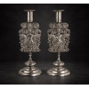 <p>Par de castiçais de prata-de-lei regional sem contraste, finamente cinzelados, ornamentados com figura feminina semi-desnuda e símbolos de colheita, ramagens e guirlandas, placa apoiada sobre base de madeira nobre. Alt. 35 x 13 x 13cm. América do Sul, séc. XVIII (peso total com madeira 1.590 gramas)</p>