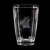 <p>VICKE LINDSTRAND PARA ORREFORS - Elegante floreiro em cristal incolor de formato trapezoidal, com cantos facetados e paredes espessas, produzido pela renomada manufatura sueca Orrefors e desenhado por Vicke Lindstrand, um dos grandes mestres do vidro escandinavo do século XX. Na face frontal, apresenta a gravação manual em baixo-relevo de um veleiro sobre fundo acetinado, composição típica da poética nórdica de Lindstrand, que unia clareza formal e refinamento técnico. Leve bicado na borda. Assinado Orrefors L. 3167 na base. 23 cm (altura), 13 cm x 10 cm. (Ligeiro lascado na borda).</p>
