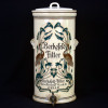 <p>BEKERFELD FILTER - Gessellschaft, Celle - GERMANY- Antigo filtro de &aacute;gua em cer&acirc;mica vitrificada, ao estilo Art Nouveau final do s&eacute;c. XIX. Dois apoios laterais &agrave; guisa de al&ccedil;as.<br />*O elemento filtrante do interior j&aacute; encontra-se descartado; tampa adaptada.<br />Medidas:...........................................................cm.<br /><br />HIST&Oacute;RICO: Este tipo de filtro foi inventado em 1891 por um engenheiro alem&atilde;o, Wilhelm Berkefeld (1836-1897). Ele era o propriet&aacute;rio de uma mina de terra diatom&aacute;cea em Celle, Alemanha, da qual fornecia mat&eacute;ria-prima para a camada de filtragem feita de terra diatom&aacute;cea (diatomita), que &eacute; uma rocha organog&ecirc;nica formada principalmente de fr&uacute;stulas. <br /><br />Berkefeld observou que, em condi&ccedil;&otilde;es naturais, a terra diatom&aacute;cea atua como um filtro de &aacute;guas subterr&acirc;neas. Ele usou essa observa&ccedil;&atilde;o para criar um filtro, no qual a terra diatom&aacute;cea serviu como material de filtro.<br /><br />Filtros baseados na ideia de Berkefeld foram usados com sucesso durante a epidemia de c&oacute;lera em Hamburgo em 1892 e existe um parecido no Pharmacy Museum da Jagiellonian University Medical College.<br /><br />A partir de 1922 passou a ser distribu&iacute;do pelo Reino Unido. Este exemplar, embora exibindo d&iacute;sticos em ingl&ecirc;s, traz os dizeres Made in Germany.</p>