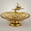 <p>Antigo centro de mesa ou porta cart&otilde;es encimado por cupido carregando correspond&ecirc;ncia e aljava com flechas de ca&ccedil;a. Consta monograma e data&ccedil;&atilde;o: 28/mai/1851- 28/mai/ 1876. Europa, s&eacute;culo XIX. Bronze e metal dourado. MED: 25 X 33 X 33 cm.</p>
