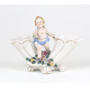 <p>Dresden, cornucópia em porcelana alemã, decorada com figura de puto e flores. 15 cm alt, 20 x 6 cm.(Necessita Restauro).</p>