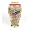 <p>Delicado vaso de porcelana Satsuma, com forma alongada de borda estreita e corpo bojudo, inteiramente decorado com cenas de pavões em meio a ramos de sakura (flor de cerejeira), símbolo de beleza efêmera na cultura japonesa. A paleta em tons de dourado, vermelho ferrugem e azul-cobalto destaca-se pela aplicação rica de ouro em relevo (moriage), contrastando com o fundo marfim craquelado, típico das manufaturas Satsuma do período Meiji. Na base, apresenta marca caligráfica em cartela vermelha com caracteres dourado, 37 cm alt. 17 cm diâm.</p>