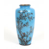 <p>Belíssimo vaso japonês de cloisonné, de corpo alongado com base e boca circulares. O fundo em esmalte azul celeste translúcido serve de cenário para uma delicada composição de ramos de cerejeira em flor, com pequenas flores brancas e rosadas detalhadas com fios de cobre, além de pequenos pássaros em voo entre os galhos. A peça é finalizada com bordas metálicas escurecidas e fundo em bronze marcado. Selo da oficina Hayashi Kodenji , um dos mais renomados mestres do cloisonné de Nagoya, ativo no final do século XIX ao início do século XX. (período Meiji).vaso cloisonne azul celestial - 32 cm alt, 14 cm diâm. (Apresenta trinca no esmalte)</p>