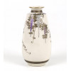 <p>Elegante vaso em porcelana Satsuma, moldado em forma de baluster alongado com boca levemente aberta e filetes dourados na borda. A decoração é composta por delicados ramos de glicínias (fuji), com cachos de flores em esmalte lilás e branco, delineados com finos traços dourados (moriage), sobre fundo marfim com craquelê fino, característico das peças de exportação do final do período Meiji (1868-1912). O detalhe minimalista e a composição harmoniosa refletem a estética refinada da escola Satsuma de Kyoto, voltada para o mercado ocidental. Na base, apresenta o brasão do Clã Shimazu (círculo com cruz central), acompanhado da assinatura Shuzan ou Tamayma em cartela vermelha com douração. vaso satsuma conico flores - 15,5 cm.</p>