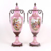 <p>Par de ânforas de porcelana esmaltada na tonalidade rosa , reserva central com cenas bucólicas . França Sec XX – 51 cm alt, 14 cm diâm.</p>