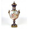 <p>Belíssima ânfora em porcelana esmaltada e bronze, com rico trabalho. Reserva central representando cena de casal. Manufatura Sèvres. França, séc. XIX. 75 cm de alt.; 26 cm de diâm.</p> <p>Belíssima ânfora em porcelana esmaltada e bronze, com rico trabalho. Reserva central representando cena de casal. Manufatura Sèvres. França, séc. XIX. 75 cm de alt.; 26 cm de diâm.</p>