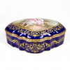 <p>Bela caixa em porcelana esmaltada na tonalidade azul cobalto, decorado com reserva central representando cena rom&acirc;ntica, borda em bronze dourado, 13 cm alt, 32 x 22 cm. Fran&ccedil;a Sec XIX</p>