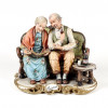 <p>Capodimonte &ndash; Belo grupo escult&oacute;rico em porcelana esmaltada e policromada, representando casal de idosos observando recorda&ccedil;&otilde;es, intitulado Ricordi. 24 cm de alt.; 27 x 20 cm. It&aacute;lia, s&eacute;c. XX.</p>