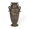 <p>Elegante vaso japonês em bronze patinado, com delicada decoração em incrustações de cobre, prata e shakudo (liga de cobre com ouro), representando composição floral com folhas e flores variadas, além de pássaros minuciosamente delineados em voos e repouso. O corpo de formato cilíndrico alongado repousa sobre base circular, destacando-se pelas alças laterais estilizadas em forma de dragões ou quimeras, de fino trabalho em relevo. A boca larga e abaulada apresenta borda suavemente ressaltada. Peça exemplar da tradição de marqueterie em metais do período Meiji (1868-1912), técnica que combina diversas ligas de metais preciosos sobre o fundo de bronze, formando um contraste refinado de texturas e cores, típico das manufaturas de Tóquio e Kyoto. Obra de sofisticada execução, com riqueza de detalhes e naturalismo nas representações. Japão, Período Meiji, circa 1900- 35 cm alt.</p> <p>Elegante vaso japonês em bronze patinado, com delicada decoração em incrustações de cobre, prata e shakudo (liga de cobre com ouro), representando composição floral com folhas e flores variadas, além de pássaros minuciosamente delineados em voos e repouso. O corpo de formato cilíndrico alongado repousa sobre base circular, destacando-se pelas alças laterais estilizadas em forma de dragões ou quimeras, de fino trabalho em relevo. A boca larga e abaulada apresenta borda suavemente ressaltada. Peça exemplar da tradição de marqueterie em metais do período Meiji (1868-1912), técnica que combina diversas ligas de metais preciosos sobre o fundo de bronze, formando um contraste refinado de texturas e cores, típico das manufaturas de Tóquio e Kyoto. Obra de sofisticada execução, com riqueza de detalhes e naturalismo nas representações. Japão, Período Meiji, circa 1900- 35 cm alt.</p>