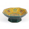 <p>Taça de porcelana japonesa de base octogonal elevada, com bojo profundo e borda aberta, decorada em esmaltes policromados em relevo (moriage). O interior apresenta decoração central com fênix estilizada (hō-ō) cercada por arabescos, rodeada por reservas alternadas de mon (emblemas heráldicos) e flores estilizadas em tonalidades de verde esmeralda e violeta sobre fundo mostarda. As paredes internas possuem aplicação de esmaltes em alto relevo (moriage), conferindo textura e profundidade ao desenho. A base octogonal em tom verde profundo esmaltado completa a composição. A marca sob a base, embora parcialmente desgastada, sugere produção de estúdio tradicional do estilo Kutani, famoso por seus esmaltes vibrantes e decoração refinada. Peça representativa do período de transição entre a cerâmica tradicional e a produção voltada para exportação no Japão do século XIX. Período: Meiji (c. 1880-1900) - Japão, estilo Kutani - 10 cm alt. 26 cm diâm.</p> <p>Taça de porcelana japonesa de base octogonal elevada, com bojo profundo e borda aberta, decorada em esmaltes policromados em relevo (moriage). O interior apresenta decoração central com fênix estilizada (hō-ō) cercada por arabescos, rodeada por reservas alternadas de mon (emblemas heráldicos) e flores estilizadas em tonalidades de verde esmeralda e violeta sobre fundo mostarda. As paredes internas possuem aplicação de esmaltes em alto relevo (moriage), conferindo textura e profundidade ao desenho. A base octogonal em tom verde profundo esmaltado completa a composição. A marca sob a base, embora parcialmente desgastada, sugere produção de estúdio tradicional do estilo Kutani, famoso por seus esmaltes vibrantes e decoração refinada. Peça representativa do período de transição entre a cerâmica tradicional e a produção voltada para exportação no Japão do século XIX. Período: Meiji (c. 1880-1900) - Japão, estilo Kutani - 10 cm alt. 26 cm diâm.</p>