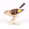 <p>Escultura de porcelana Goebel (Fábrica alemã Goebel Porzellan, fundada no final do século XIX, reconhecida mundialmente pela produção de porcelanas finas. A empresa, com forte mercado nos EUA, combina tradição artística com rigorosa qualidade.), Pássaro зobre troncos (possivelmente um Papa-figos), com detalhes pintados à mão. A marca d’água no verso da base se trata da marca de autenticidade da fabricante W Germany, indica que foi fabricado na Alemanha Ocidental, no período antes da reunificação alemã em 1660. 12,5 cm alt x 13 cm larg.</p> <p>Escultura de porcelana Goebel (Fábrica alemã Goebel Porzellan, fundada no final do século XIX, reconhecida mundialmente pela produção de porcelanas finas. A empresa, com forte mercado nos EUA, combina tradição artística com rigorosa qualidade.), Pássaro зobre troncos (possivelmente um Papa-figos), com detalhes pintados à mão. A marca d’água no verso da base se trata da marca de autenticidade da fabricante W Germany, indica que foi fabricado na Alemanha Ocidental, no período antes da reunificação alemã em 1660. 12,5 cm alt x 13 cm larg.</p>
