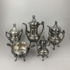 <p>Aparelho de chá e café, Reed & Barton - Estados Unidos, século XIX/XX. Aparelho de chá e café, composto de bule para café, bule para chá, leiteira e dois açucareiros. Todos de pewter espessurados de prata, com decoração floral em relevos, seguindo o estilo e época Art Nouveaus, e faixas com reservas decoradas com motivos diversos; 35 cm à 13 cm de altura. No reverso das peças marcas de identificação: MF'D & plated by / Reed & Barton / 2990. Origem: espólio de Cárbia Sabatel Bourroul e José Celestino Monteiro de Barros Bourroul.</p>