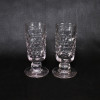 <p>Par de copos de grosso vidro translúcido, decorados com esferas em baixo relevo, em todo o corpo cilíndrico; apoiados em bases circulares; 18 cm de altura, cada. Europa, séc. XIX.</p>