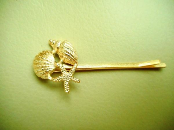 grampo conchinhas dourado